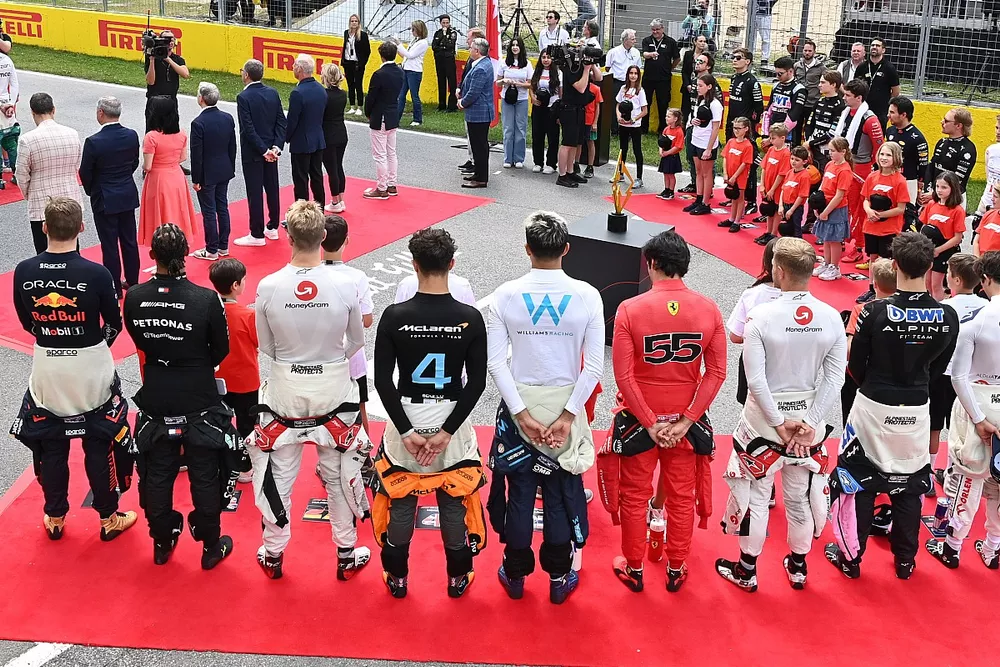 The drivers, officials and dignitaries stand on the grid for the national anthem prior to the start