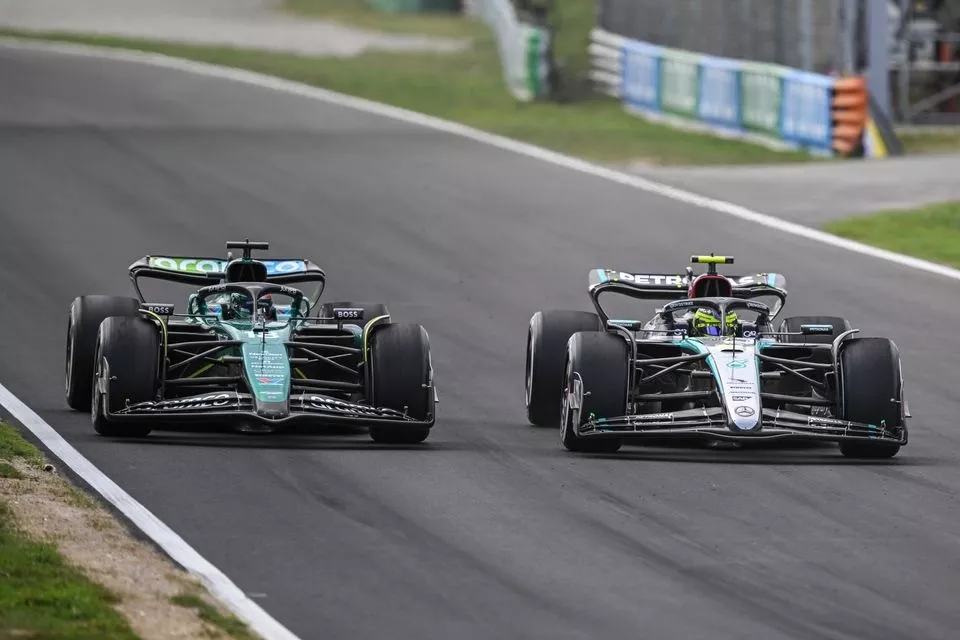 Lance Stroll, Aston Martin AMR24, battles with Lewis Hamilton, Mercedes F1 W15