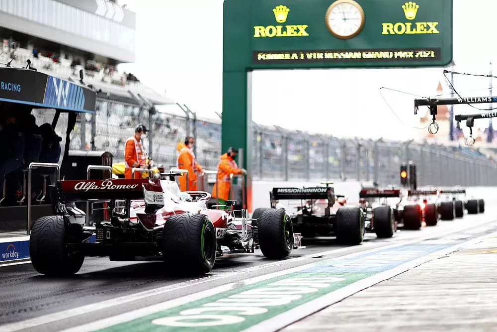 Carlos Sainz Jr., Ferrari SF21, Antonio Giovinazzi, Alfa Romeo Racing C41, en el pit lane