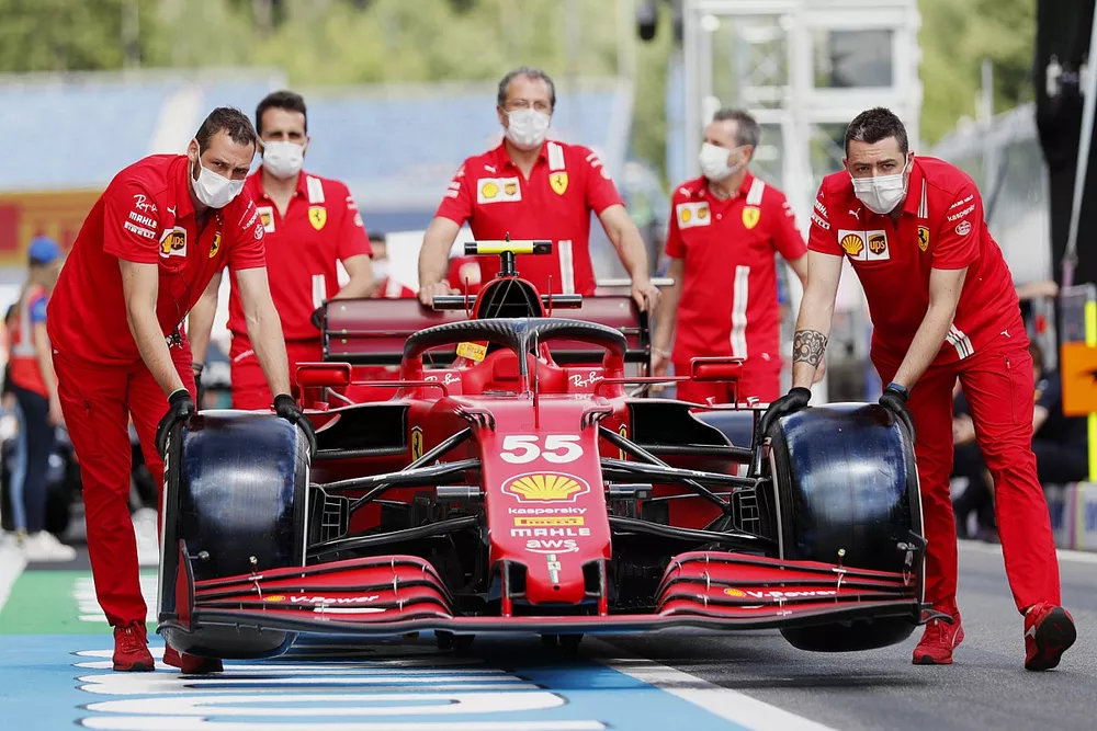 Los mecánicos de Ferrari empujan el coche de Carlos Sainz Jr., el Ferrari SF21, por el pitlane