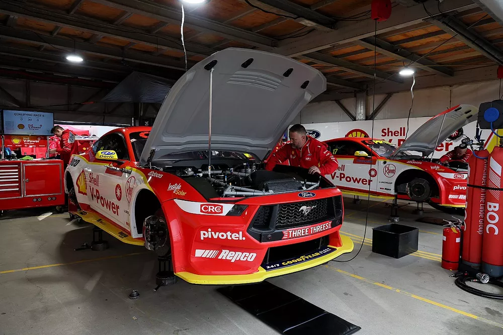 A Dick Johnson Racing team member services one of their Ford Mustangs in the garage 