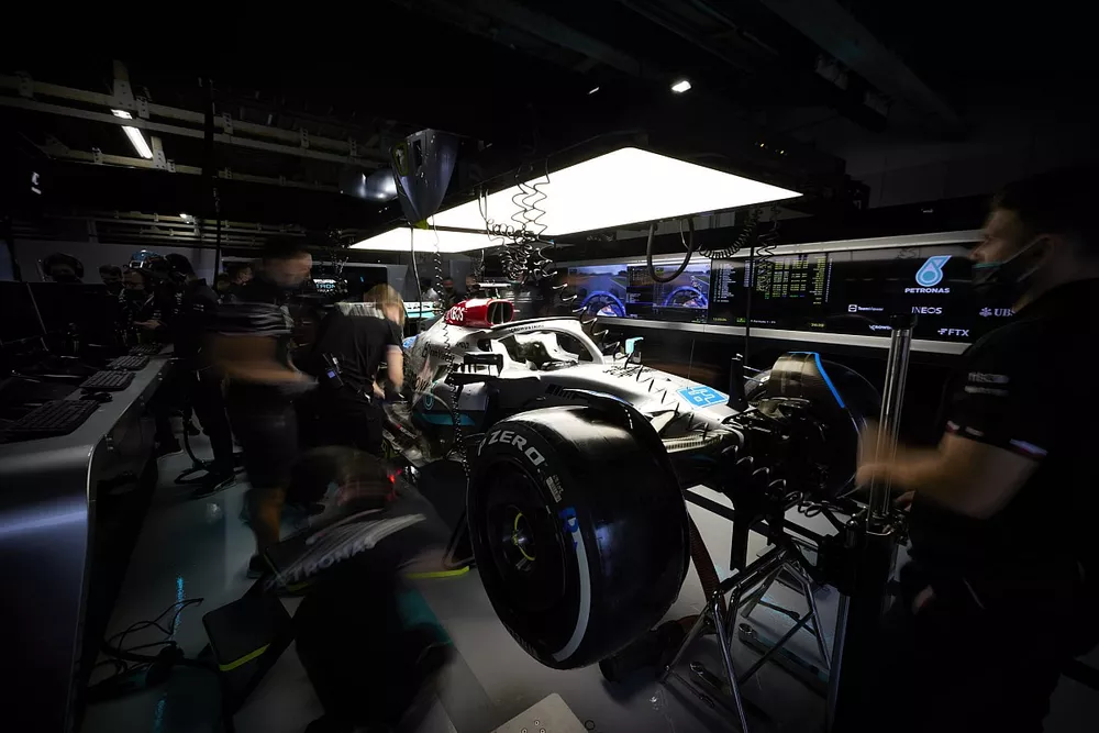 Les m&eacute;caniciens travaillent sur la monoplace de George Russell Mercedes W13 dans son garage