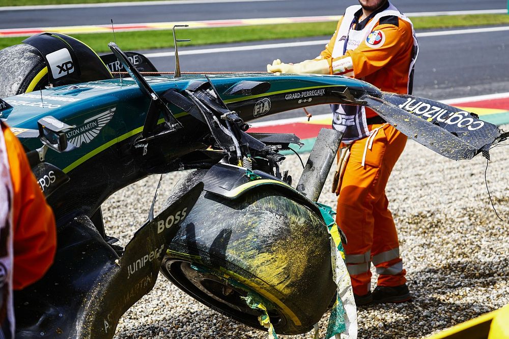 Oficiales de pist retiran el coche dañado de Lance Stroll, Aston Martin AMR23, del circuito