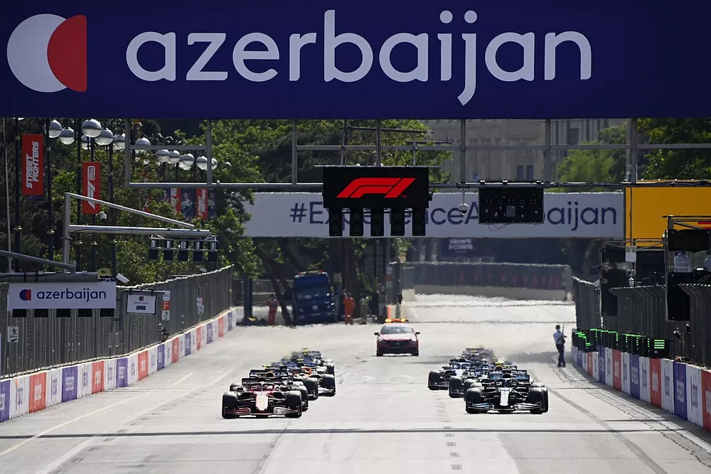 Charles Leclerc, Ferrari SF21, and Lewis Hamilton, Mercedes W12, lead the field away at the start