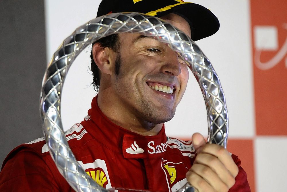El tercer clasificado Fernando Alonso, Ferrari, celebra en el podio con el troeo de Singapur