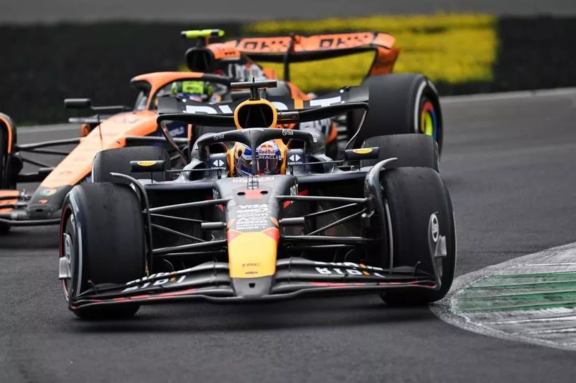 Max Verstappen, Red Bull Racing RB20 defends from Lando Norris, McLaren MCL38 