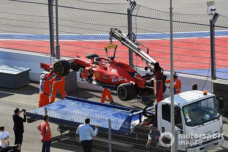 Los oficiales cargan el coche de Sebastian Vettel, Ferrari SF90, en una grúa