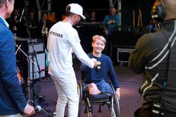 Lewis Hamilton, Mercedes AMG F1 en el escenario con con el piloto de British Formula 4 Billy Monger