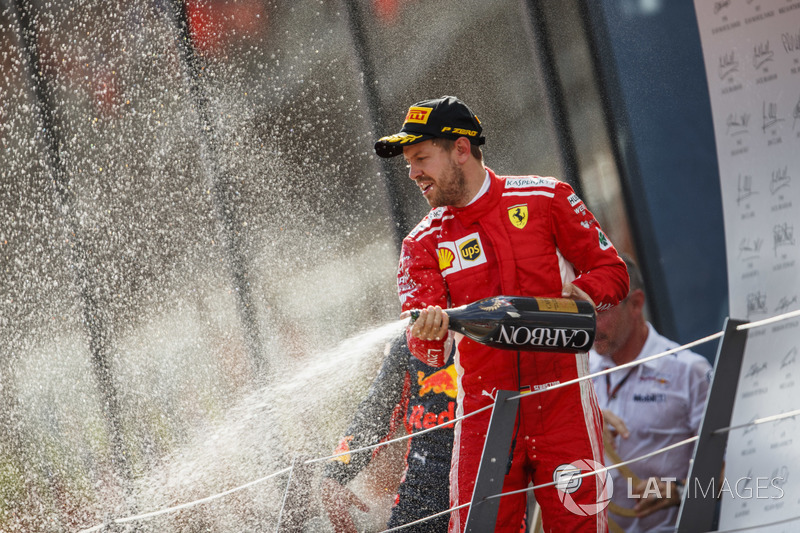 Sebastian Vettel, Ferrari, 3° classificato, spruzza lo Champagne sul podio