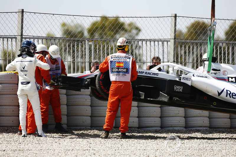 Lance Stroll, Williams Racing, studies his car after running into a gravel bed in FP1