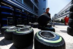 A Red Bull team member works on Pirelli tyres in the paddock