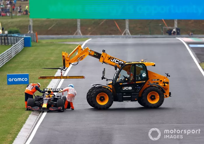 Los oficiales de pista retiran el coche dañado de Sergio Pérez, Red Bull Racing RB16B