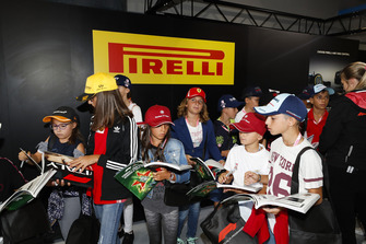 Kids wait in the Pirelli garage for autographs