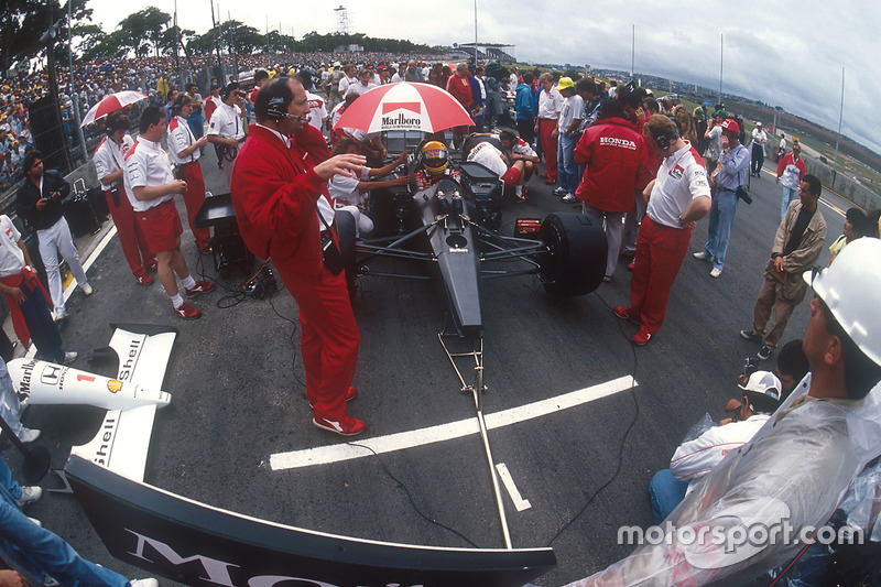 Ayrton Senna, McLaren MP4/6 Honda, sits in pole position on the grid, with team boss Ron Dennis and chief designer Neil Oatley in front