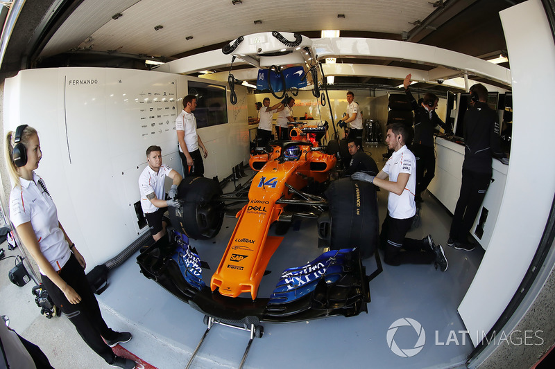 Fernando Alonso, McLaren MCL33, is attended to by mechanics in his pit garage