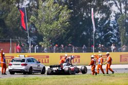Romain Grosjean, Haas F1 Team, exits his damaged car after an opening lap accident