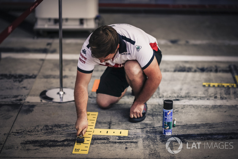 Un mécanicien Sauber prépare l'emplacement aux stands