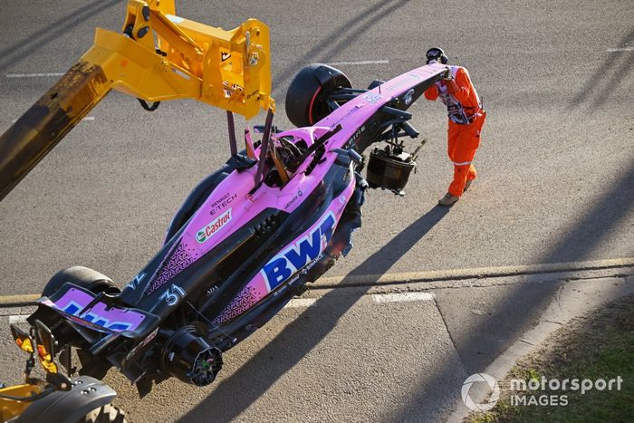 Oficiales de pista retiran el coche dañado de Esteban Ocon, Alpine A523, del circuito tras la carrera