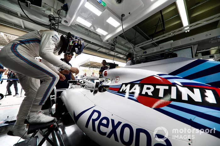 Lance Stroll, Williams Racing, enters his cockpit in the team's garage