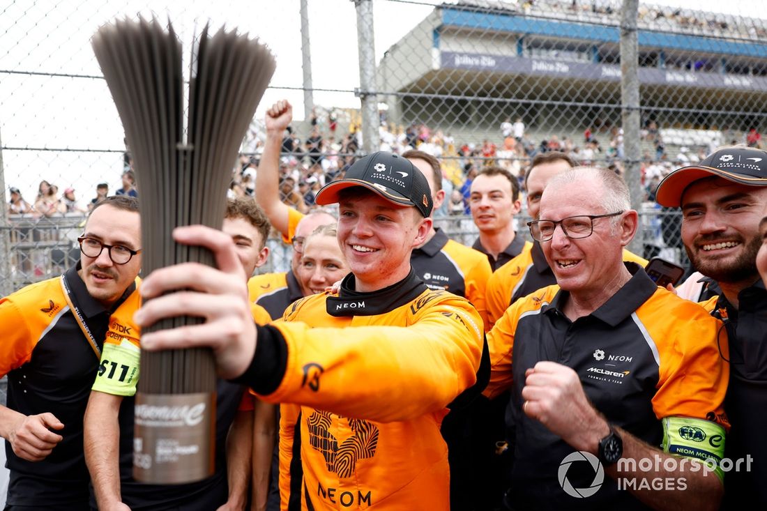 Taylor Barnard , segundo clasificado del equipo NEOM McLaren de Fórmula E, sostiene el trofeo mientras lo celebra con el equipo.
