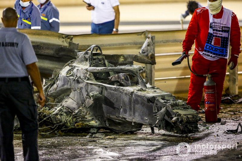 Marshals deal with the wreckage after a huge crash for Romain Grosjean, Haas VF-20, on the opening lap