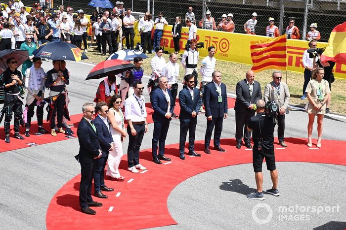 La dirección de la F1, los dignatarios, los invitados y los pilotos se sitúan en la parrilla para escuchar el himno nacional antes de la salida 