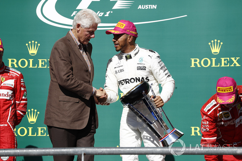 Former US President Bill Clinton presents Race winner Lewis Hamilton, Mercedes AMG F1, with the winners trophy