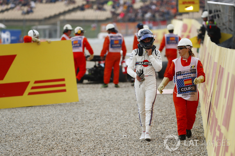 Lance Stroll, Williams Racing, is escorted by a marshal from his wrecked car