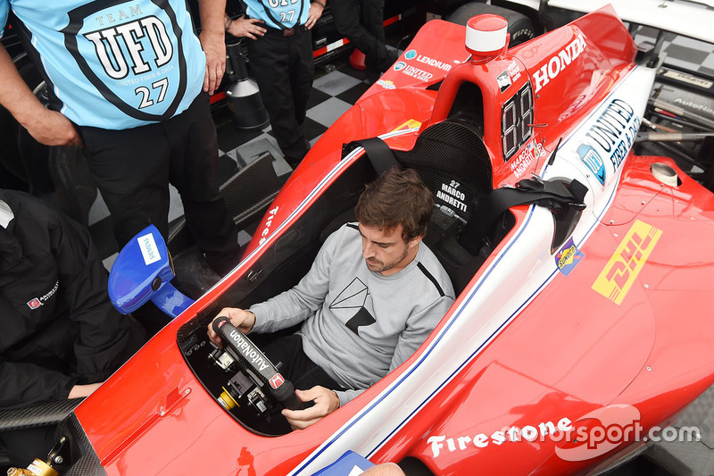 Fernando Alonso sits in the car of Marco Andretti