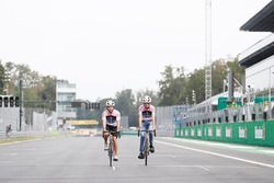 Esteban Ocon, Force India y Sergio Pérez, Force India, andan por el circuito en bicicleta