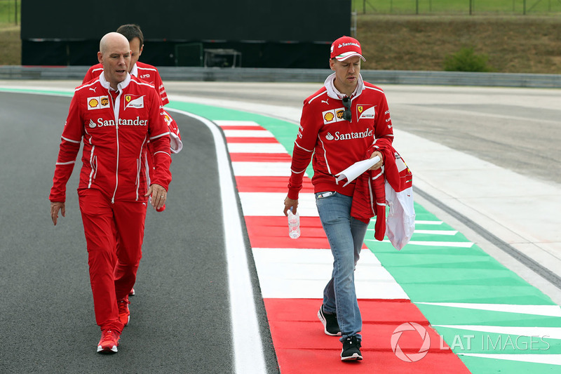 Sebastian Vettel, Ferrari y Jock Clear, Ferrari jefe de ingenieros caminan en la pista