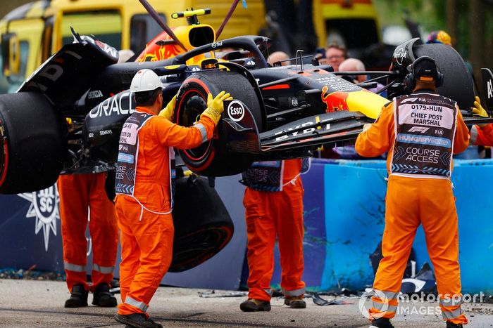 Los comisarios retiran el coche dañado de Sergio Pérez, Red Bull Racing RB20