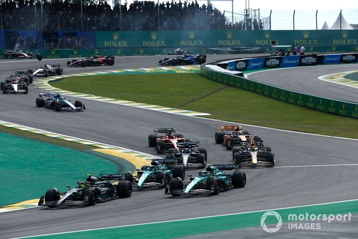Lewis Hamilton, Mercedes F1 W14, Fernando Alonso, Aston Martin AMR23, Lance Stroll, Aston Martin AMR23, el resto de la parrilla en la salida mientras Alex Albon, Williams FW45, Kevin Magnussen, Haas VF-23, chocan al fondo.