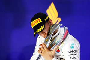 Lewis Hamilton, Mercedes AMG F1, kisses his trophy on the podium as he celebrates after winning the race