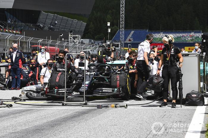 Los miembros del equipo Mercedes se arrodillan en la parrilla
