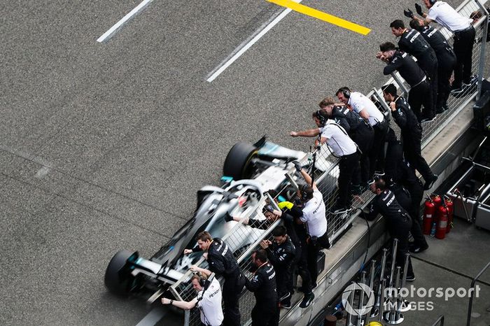 Lewis Hamilton, Mercedes AMG F1 W10 crosses the finish line in front of his team celebrating 