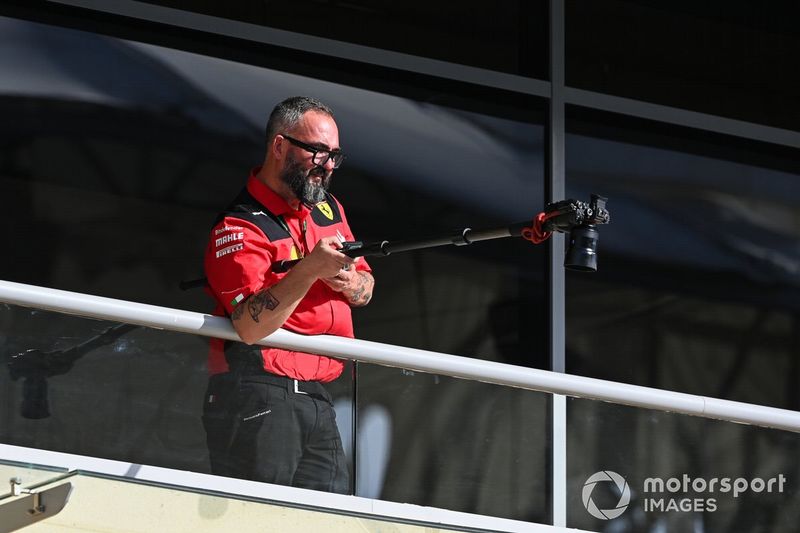 Un miembro del equipo Ferrari filma en el paddock