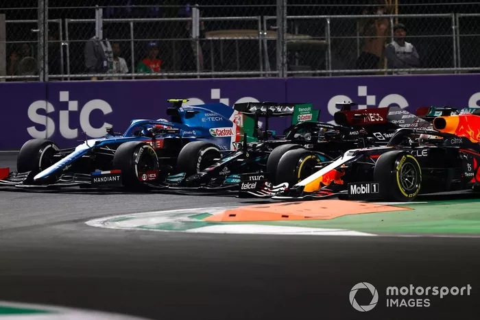 Max Verstappen, Red Bull Racing RB16B, Lewis Hamilton, Mercedes W12, y Esteban Ocon, Alpine A521, luchan por el liderato en el segundo reinicio