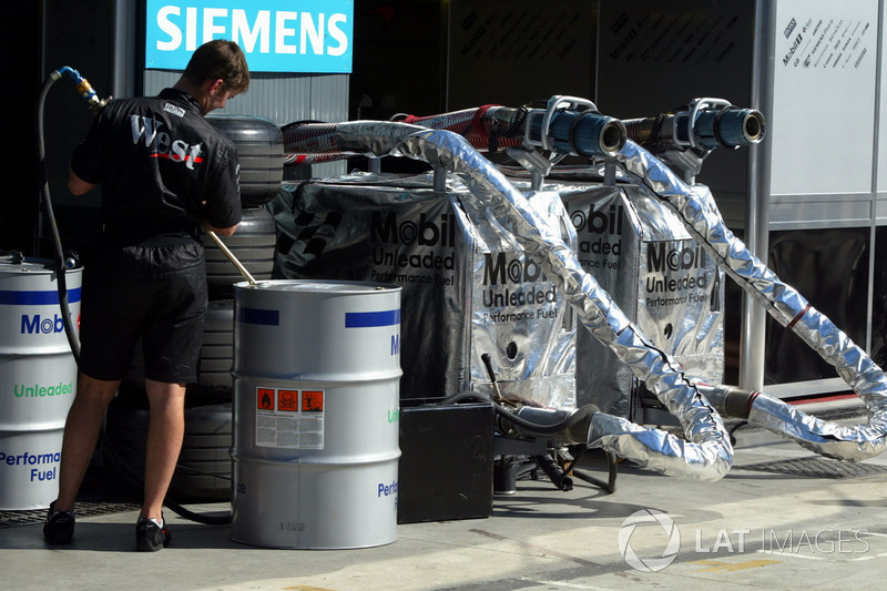 A McLaren mechanic prepares Mobil fuel in the pits