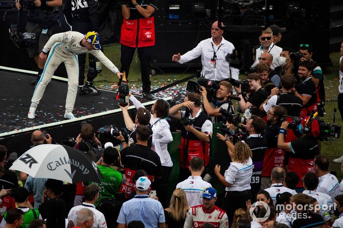 Stoffel Vandoorne, Mercedes-Benz EQ, segundo, pasa su botella de champán a su equipo