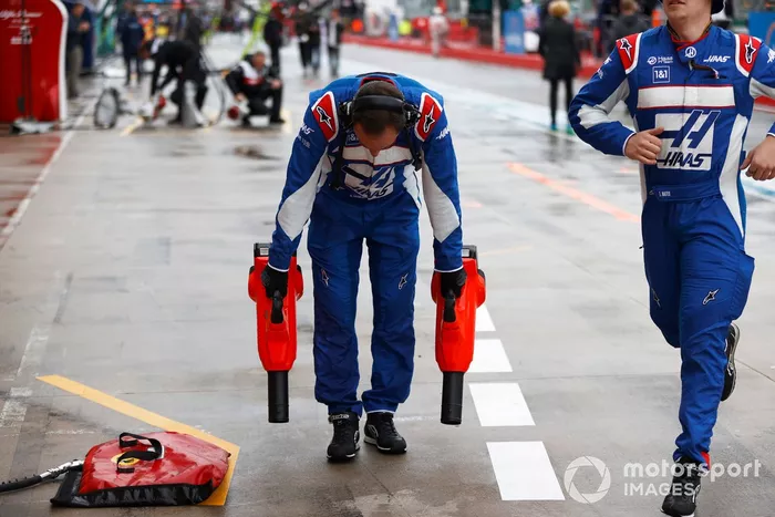 Un miembro del equipo de boxes de Haas F1 seca el box