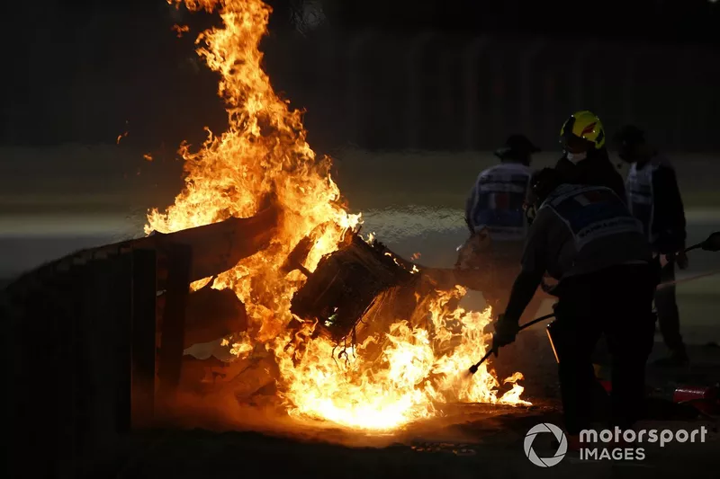 Marshals extinguish the flames after a big crash for Romain Grosjean, Haas VF-20, on the opening lap
