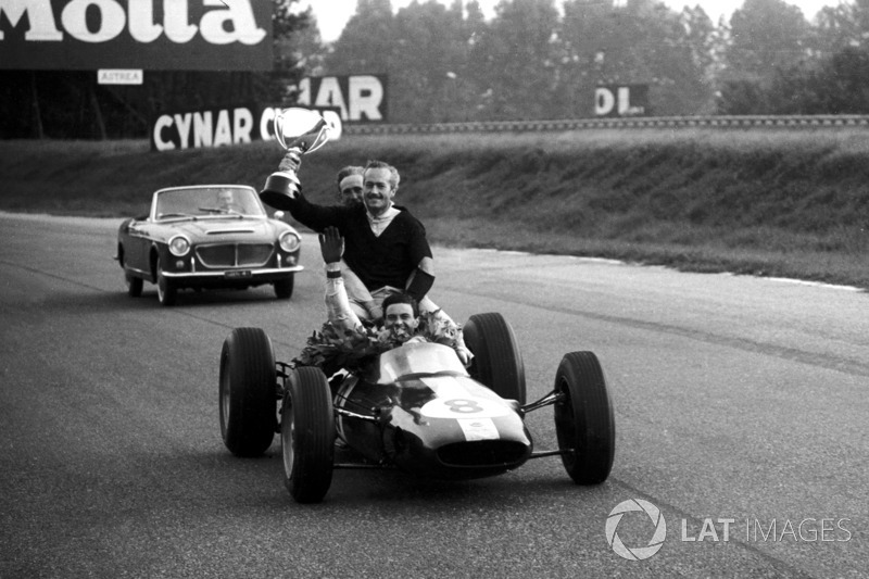 Racewinnaar Jim Clark, Lotus 25 geeft Colin Chapman, Lotus Team Owner een lift