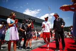 Grid Girls in national costume flank the drivers parade as Lewis Hamilton, Mercedes AMG F1, and Fernando Alonso, McLaren, pass