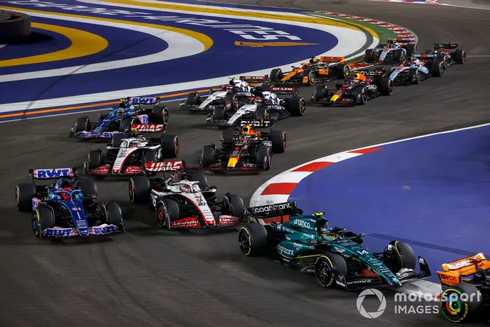 Fernando Alonso, Aston Martin AMR23, Kevin Magnussen, Haas VF-23, Esteban Ocon, Alpine A523, Nico Hulkenberg, Haas VF-23, Max Verstappen, Red Bull Racing RB19, el resto de la parrilla en la primera vuelta.