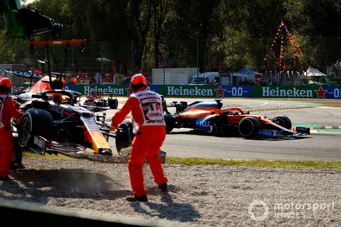 Daniel Ricciardo, McLaren MCL35M, pasa mientras retiran el coche de Max Verstappen, Red Bull Racing RB16B, de la grava