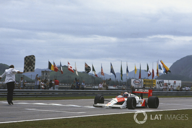 Alain Prost, McLaren MP4/4, takes the chequered flag