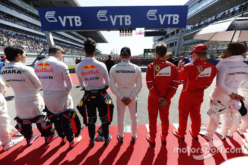 The drivers line up for the national anthem