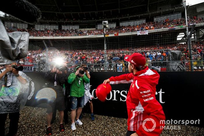 Sebastian Vettel, Ferrari, lanza una gorra a la multitud