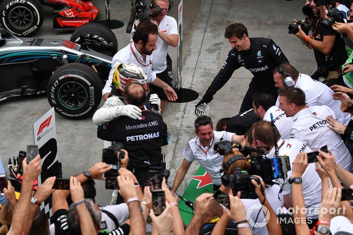 Las barreras se derrumban cuando Lewis Hamilton, Mercedes AMG F1 celebra con su mecánica en el Parc Ferme.